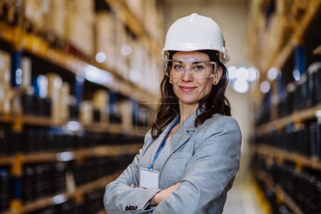 Photo for Manager woman in suit controlling goods in warehouse. - Royalty Free Image