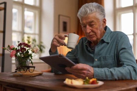Photo for Senior man reading something in a digital tablet. - Royalty Free Image
