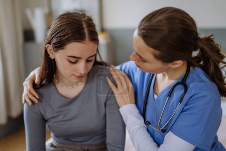 Photo for Young nurse taking care of a teenage girl, consoling her. - Royalty Free Image