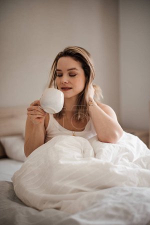 Téléchargez les photos : Portrait de jeune femme le matin dans un lit. - en image libre de droit
