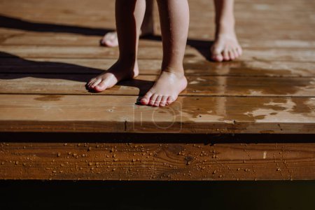 Téléchargez les photos : Section basse des pieds des enfants sur une jetée. - en image libre de droit