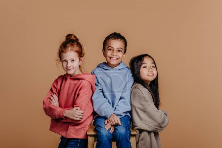 Foto de Retrato de tres niños, sesión de estudio. Concepto de diversidad en una amistad. - Imagen libre de derechos