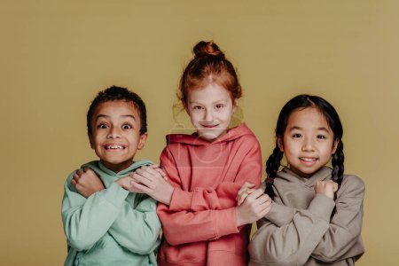Foto de Retrato de tres niños, sesión de estudio. Concepto de diversidad en una amistad. - Imagen libre de derechos