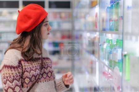 Photo for Young woman choosing a medication in a pharmacy store. - Royalty Free Image