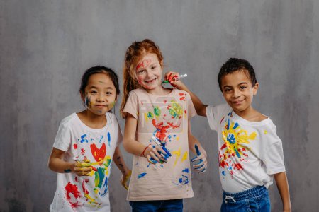 Téléchargez les photos : Portrait d'enfants heureux avec des couleurs de doigts et des t-shirts peints. - en image libre de droit