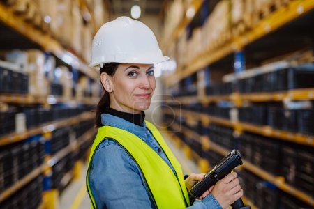 Téléchargez les photos : Warehouse female worker checking up stuff in warehouse. - en image libre de droit