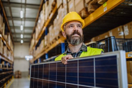 Téléchargez les photos : Portrait de travailleur d'entrepôt avec un panneau solaire. - en image libre de droit