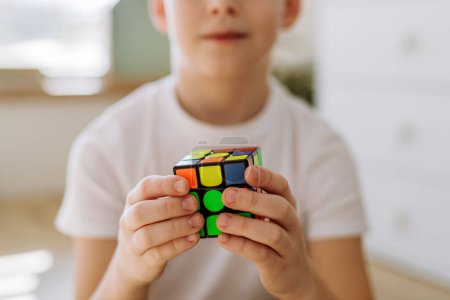 Photo for Little boy playing with Rubiks cube at home. - Royalty Free Image