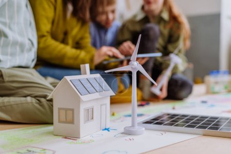 Photo for Close-up of a house model with solar system and wind turbine during a school lesson. - Royalty Free Image