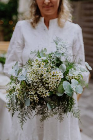 Téléchargez les photos : A close-up ofwedding bouquet in brides hands at reception outside in backyard - en image libre de droit