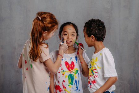Foto de Retrato de niños felices con colores de dedos y camisetas pintadas. - Imagen libre de derechos