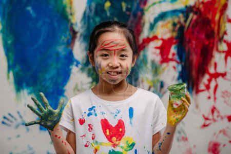 Téléchargez les photos : Portrait d'enfant heureux avec des couleurs de doigts et des t-shirts peints. - en image libre de droit
