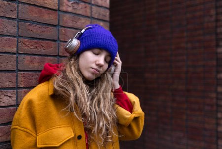 Photo for Young woman listening music outdoor, in city. - Royalty Free Image