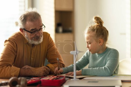 Senior man studying with his granddaughter.