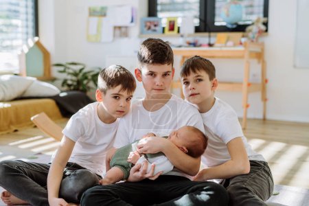 Téléchargez les photos : Trois grands frères avec leur frère nouveau-né. - en image libre de droit