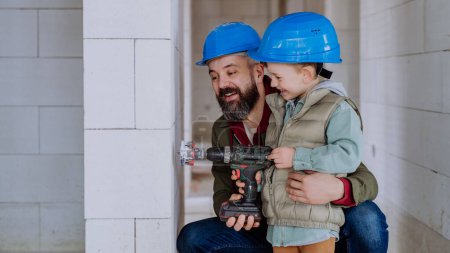 Photo for Father and his little son working together on their unfinished house. - Royalty Free Image