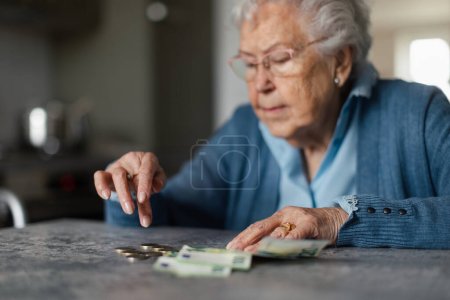 Nieszczęśliwa kobieta licząca emeryturę w domu.