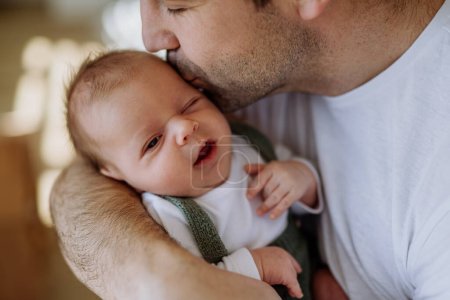 Téléchargez les photos : Gros plan de père tenant et embrassant son petit bébé nouveau-né. - en image libre de droit