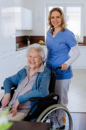 Foto de Retrato de la enfermera y su cliente senior en silla de ruedas. - Imagen libre de derechos