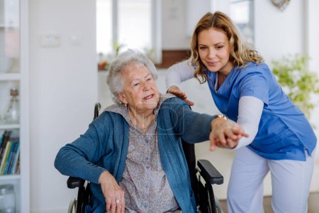 Enfermera haciendo ejercicio con una mujer mayor en su casa, concepto de asistencia sanitaria y rehabilitación.