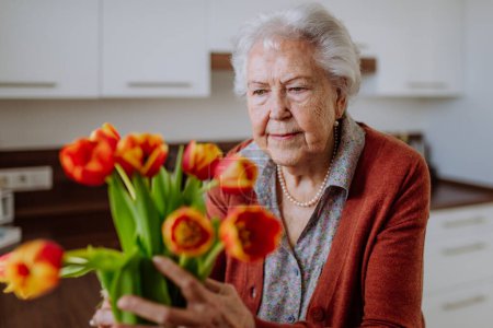 Téléchargez les photos : Portrait de femme âgée avec bouquet de fleurs. - en image libre de droit