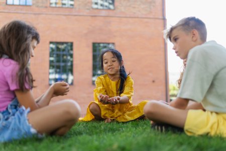 Téléchargez les photos : Happy kids playing and talking together in s city park, during summer day. - en image libre de droit