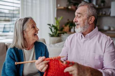 Photo for Senior couple knitting together in the living room. - Royalty Free Image
