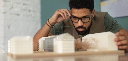 Photo for Young multiracial architect designing building in his office. - Royalty Free Image
