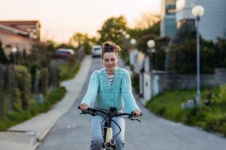 Téléchargez les photos : Jeune femme sur un vélo électrique, concept de transport quotidien et de voyage écologique. - en image libre de droit