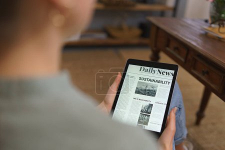 Foto de Detalle de tableta con artículo de noticias en pantalla. Mujer leyendo noticias en tableta digital. - Imagen libre de derechos