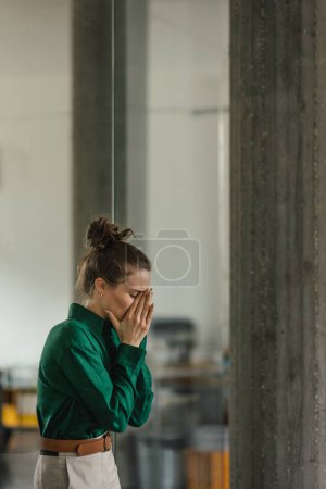 Young sad woman in office, facing a problems at work. Signs of burnout at work. Workplace issues.