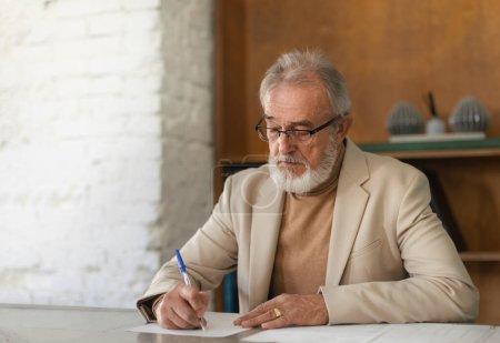 Photo for Serious eldery businessman signing document at office table. Portrait of senior man, ceo, boss signing a contract. - Royalty Free Image