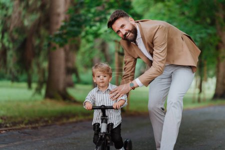 Photo for Single father with his little son spending together time in a public park. - Royalty Free Image