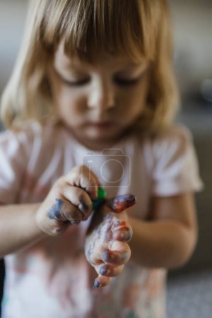 Téléchargez les photos : Portrait de petite fille aux mains sales tachées de peinture. Enfant artistique se désordre et avoir du plaisir. - en image libre de droit