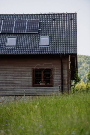 Foto de Casa familiar con paneles solares en el techo en el prado. - Imagen libre de derechos