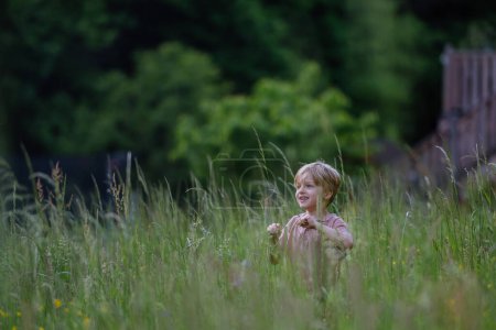 Photo for Happy boy playing and running on the meadow. - Royalty Free Image