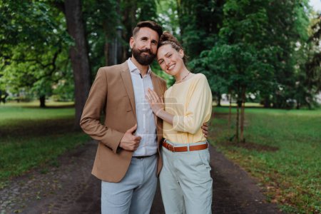 Téléchargez les photos : Jeune couple marié en promenade dans le parc de la ville après le travail. Couple de travail passe du temps à l'extérieur après une longue journée de travail. Concept d'équilibre travail-vie personnelle, - en image libre de droit