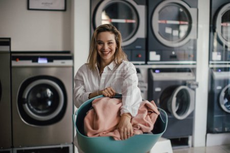 Photo for Young woman posing in the laundry room. - Royalty Free Image