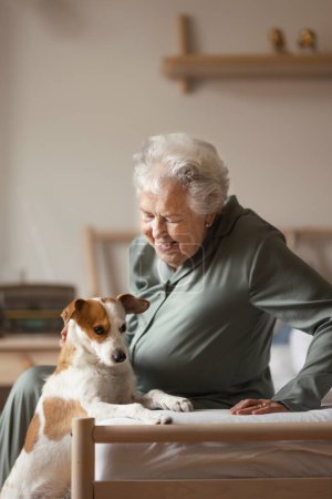 Photo for Senior woman enjoying time with her little dog at home. - Royalty Free Image
