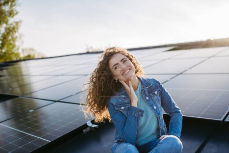 Téléchargez les photos : Portrait de jeune femme, propriétaire sur le toit avec panneaux solaires. - en image libre de droit