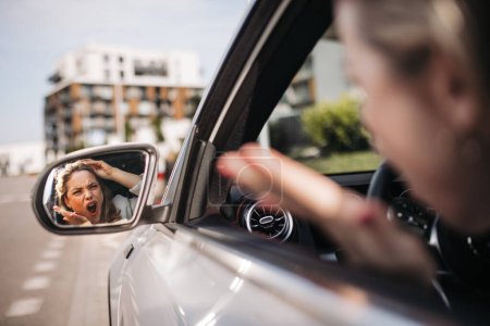 Foto de Mujer nerviosa conduciendo su coche en una ciudad, gritándole a alguien. - Imagen libre de derechos