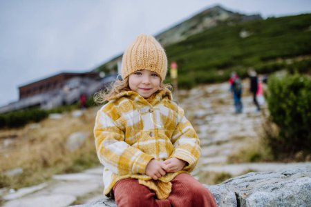 Téléchargez les photos : Portrait de petite fille lors d'une randonnée automnale en montagne. - en image libre de droit