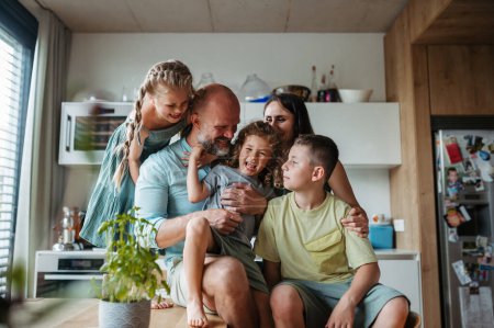 Foto de Familia alegre con tres niños divirtiéndose juntos en la cocina. Concepto de vínculo familiar. - Imagen libre de derechos