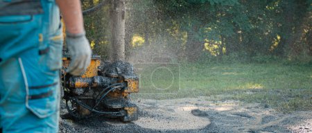 Photo for Close up of well drilling rig boring dowin into the earth. A rotary drill rig using bits to bore into ground and loosing the soil and rocks. Drilling equipment using water to cool down bits - Royalty Free Image