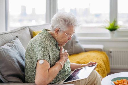 Photo for Diabetic senior patient with continuous glucose monitor feeling dizzy. Senior diabetic woman having low blood sugar. CGM device making life of elderly woman easier, helping manage her illness and - Royalty Free Image