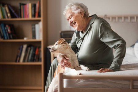 Photo for Senior woman enjoying time with her little dog at home. Dog as companion, best friends for senior. - Royalty Free Image