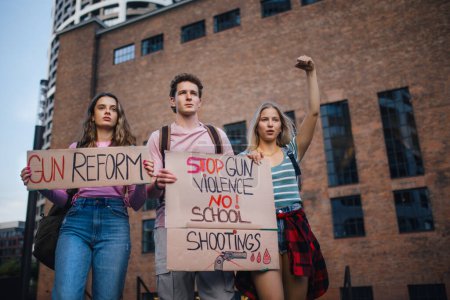 Téléchargez les photos : Militants de la génération Z avec des banderoles protestant dans la rue. Les jeunes étudiants en zoomer qui défilent dans la ville manifestent contre le changement climatique. Manifestants réclamant le contrôle des armes, la race et le genre - en image libre de droit