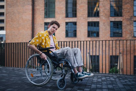 Photo for Gen Z boy in a wheelchair in the city. Inclusion, equality, and diversity among Generation Z. - Royalty Free Image