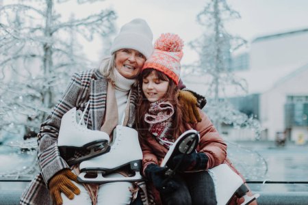 Téléchargez les photos : Grand-mère avec sa petite-fille en hiver à la patinoire extérieure. Grands-parents enseignant fille mignonne comment patiner sur glace. - en image libre de droit