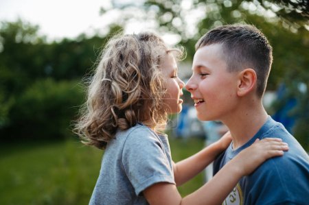 Photo for Younger and older brother are touching noses. Sibling love and a lifelong relationship. - Royalty Free Image